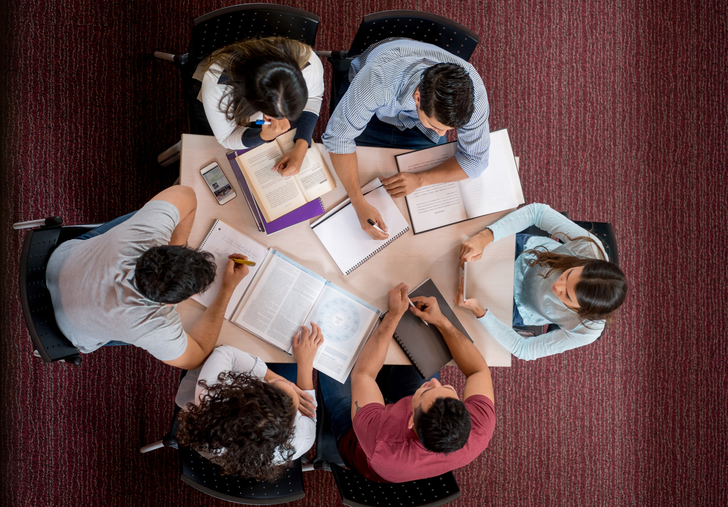 Group of college students studying together in a roundtable